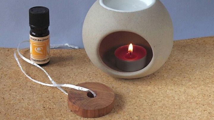 Eine duftende &Ouml;llampe mit brennender Kerze vertreibt M&uuml;cken und Wespen in einer gem&uuml;tlichen Umgebung auf einem Tisch.