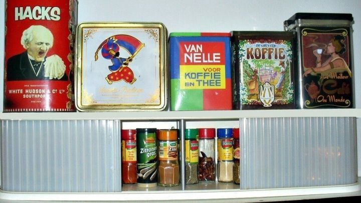 Ein umgebautes CD-Regal dient als Gew&uuml;rzschrank und zeigt dekorative Dosen mit verschiedenen Kr&auml;utern und Gew&uuml;rzen.