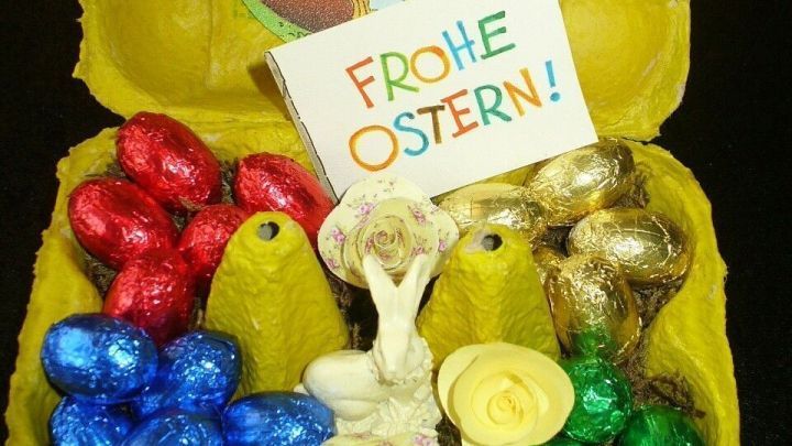 Farbenfrohe Schokolade in einer gelben Verpackung zeigt ein Ostergeschenk mit dem Aufdruck &bdquo;FROHE OSTERN!&ldquo;.