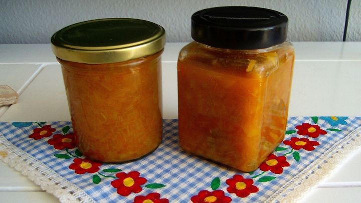 Zwei Gl&auml;ser mit Rhabarber-Mango-Chutney stehen auf einem blumigen Tischl&auml;ufer in einer hellen Umgebung.