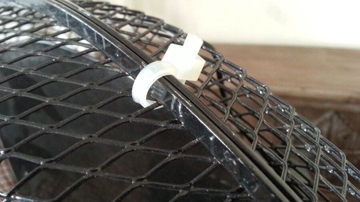 Ein Ventilator mit abgebrochenen Halterungen wird durch eine wei&szlig;e Kabelbinderreparatur fixiert, um die Funktion zu gew&auml;hrleisten.