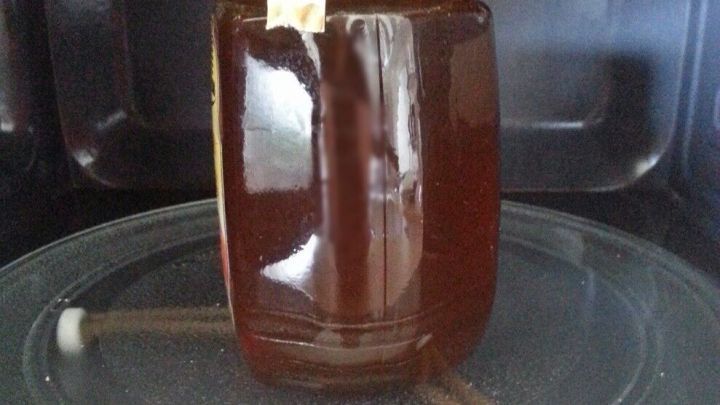 Ein Honigglas steht in der Mikrowelle und wird erw&auml;rmt, um den Inhalt fl&uuml;ssiger zu machen.