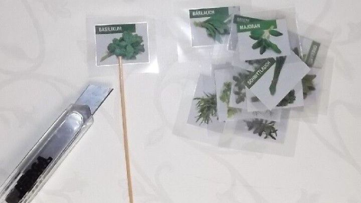 Kr&auml;utermarken stehen auf einem Tisch, w&auml;hrend ein Werkzeug daneben bereitliegt, um das Gem&uuml;se zu kennzeichnen.