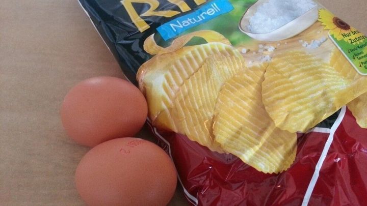 Kartoffelchips und zwei Eier liegen nebeneinander auf einem Tisch, bereit zum Einfrieren f&uuml;r sp&auml;tere Verwendung.