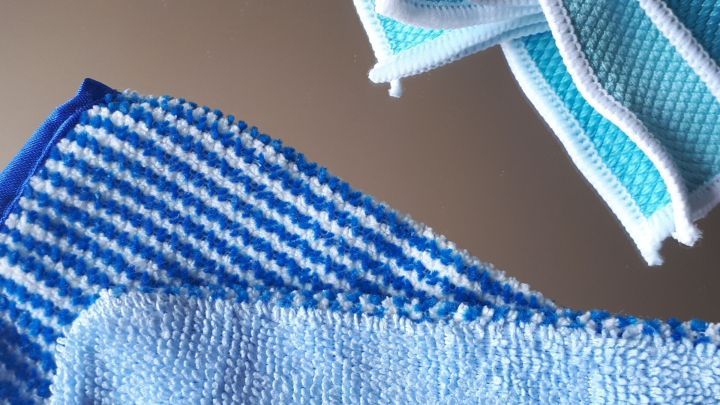 Blaue Reinigungst&uuml;cher liegen &uuml;bereinander, bereit, Spiegel ohne Chemie zu reinigen, auf einer glatten Oberfl&auml;che.