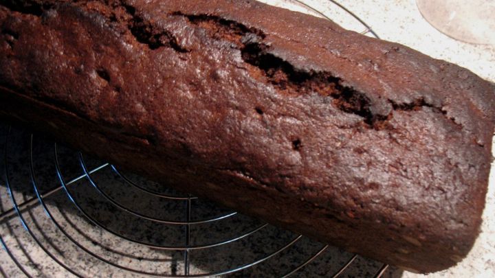 Der Schoko-Minze-Kuchen liegt auf einem Gitter, dampfend und frisch, mit einer rissigen Oberfl&auml;che in einer modernen K&uuml;che.