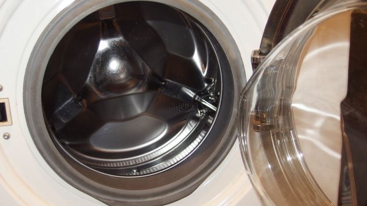 Eine ge&ouml;ffnete Frontlader-Waschmaschine zeigt die leere Trommel, w&auml;hrend sie darauf wartet, W&auml;sche zu waschen.