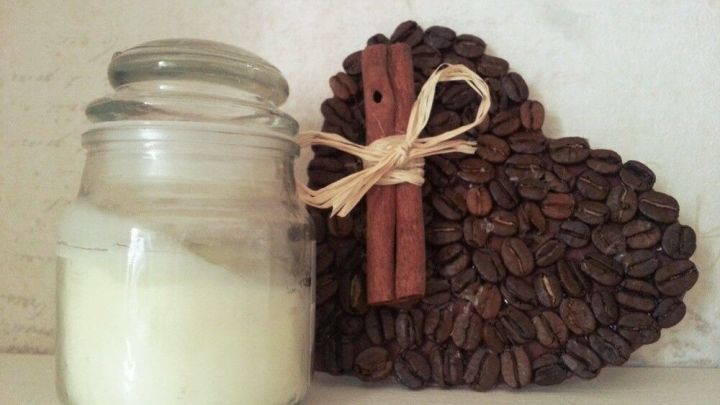 Eine Glasdose mit einer wei&szlig;en Creme steht neben einem herzf&ouml;rmigen Dekor aus Kaffeebohnen und Zimtstangen.