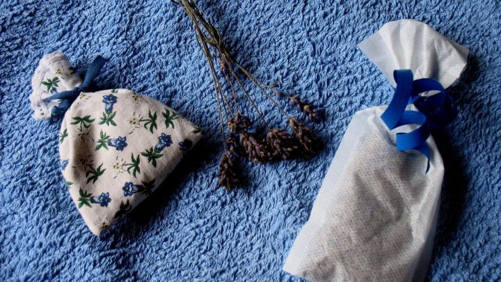 Ein Dufts&auml;ckchen liegt auf einem blauen Tuch, umgeben von getrockneten Kr&auml;utern, die zum Aromatisieren dienen.