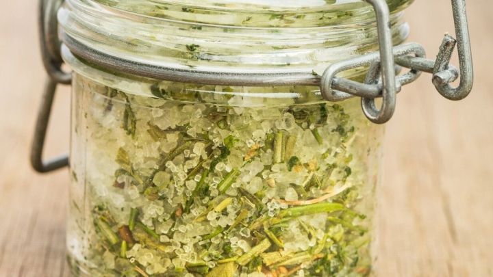 Ein Glas mit gehacktem M&ouml;hrengr&uuml;n steht auf einer Holzoberfl&auml;che, bereit zur Weiterverwendung in der K&uuml;che.