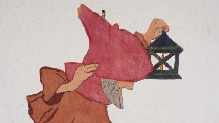 Ein fr&ouml;hlicher, bunter Gnom mit einer Laterne steht auf einem lila Teppich und strahlt gem&uuml;tliche Jugendzimmer-Atmosph&auml;re aus.