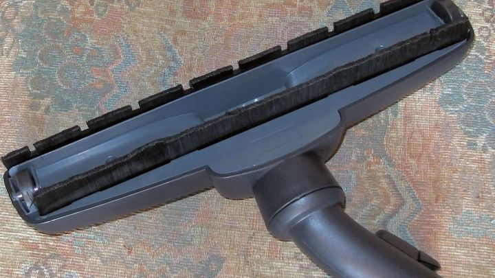 Eine Parkettb&uuml;rste liegt auf einem eleganten Teppich und ist bereit, den Boden zu reinigen und zu pflegen.