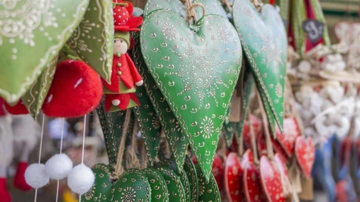 Bunte Herzchen h&auml;ngen an einer Schnur. Sie sind mit Muster verziert und zeigen eine festliche Stimmung auf dem Markt.