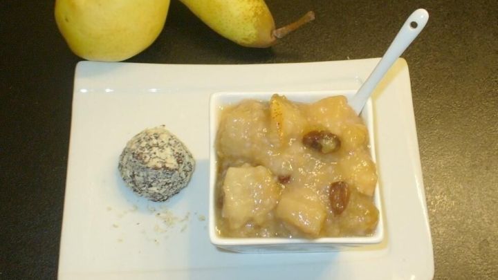 Ein wei&szlig;es Sch&auml;lchen mit Birnenkompott und Sago steht auf einem Tisch, daneben liegen zwei frische Birnen.