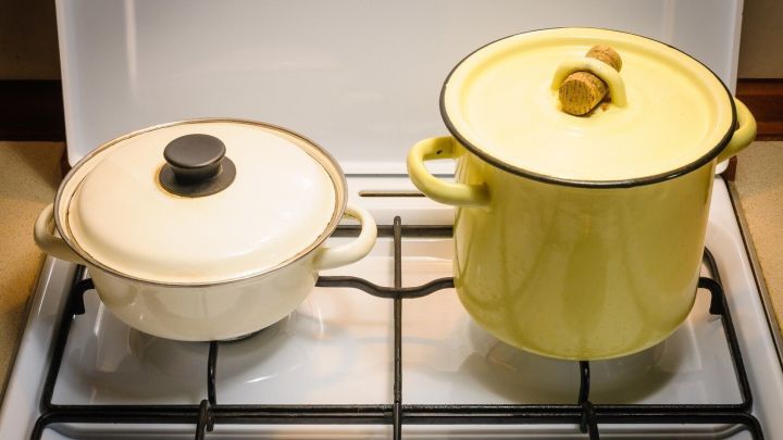 Ein gelber Kochtopf und ein wei&szlig;er Topf stehen auf einem Induktionsherd, bereit zum Kochen in der modernen K&uuml;che.