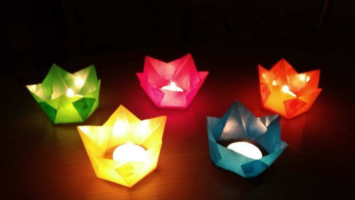 Bunte Papier-Windlichter leuchten sanft auf einem Tisch, schaffen eine festliche Atmosph&auml;re im Advent.