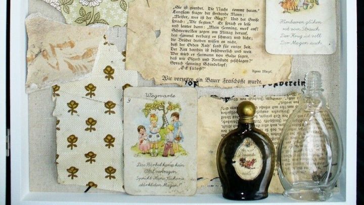 Ein Rahmen enth&auml;lt fragmente aus der Vergangenheit, wie alte Texte und Flaschen, die Erinnerungen bewahren.