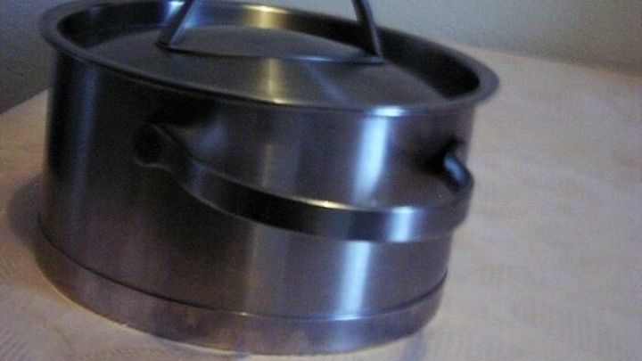 Ein Topf steht auf einer Tischdecke, bereit, Kerzenwachs zu entfernen, ohne ein B&uuml;geleisen zu verwenden.