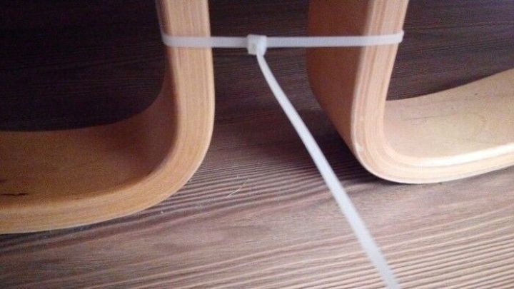 Zwei Einzelbetten sind mit einem Kabelbinder verbunden, auf einem holzboden, um eine stabile Verbindung zu schaffen.