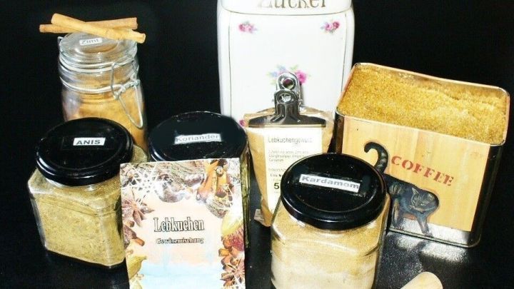 Verschiedene Zuckerdosen und Gl&auml;ser mit Advents- und Winterzucker stehen auf einem Tisch, umgeben von Zubeh&ouml;r wie L&ouml;ffeln.