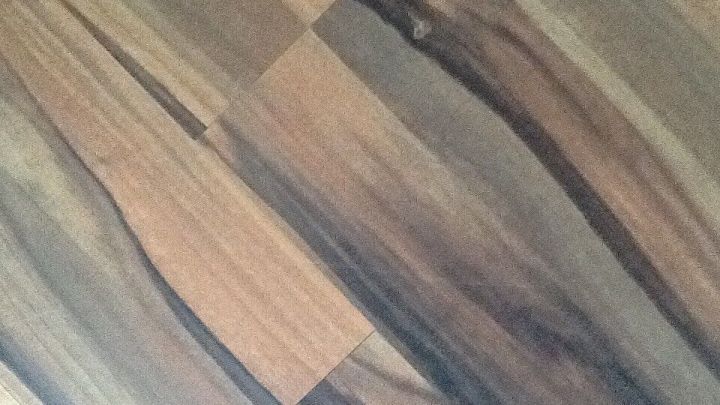 Dunkles Laminat zeigt eine strukturierte Oberfl&auml;che mit verschiedenen braunen und grauen Holzmaserungen in einem eleganten Design.