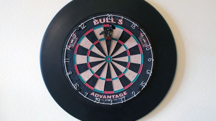 Ein Dartscheibe h&auml;ngt an der Wand, bereit f&uuml;r ein Spiel, und zeigt das typische schwarz-wei&szlig;e Feld mit dem Zielbereich.