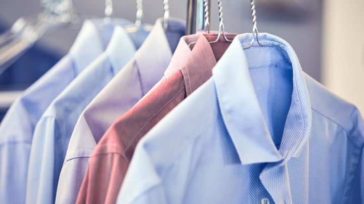 Kleiderb&uuml;gel h&auml;ngen in einer Reinigung, w&auml;hrend elegante Hemden ordentlich pr&auml;sentiert werden und auf die Abholung warten.