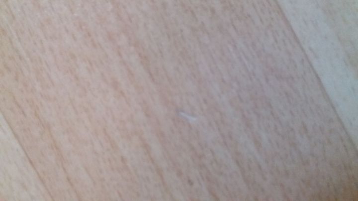 Auf dem Boden sieht man eine PVC-Oberfl&auml;che mit sichtbaren Besch&auml;digungen und Kratzern. Sie ben&ouml;tigt Ausbesserung.