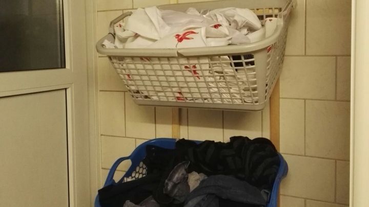 W&auml;schek&ouml;rbe sind an der Wand montiert, um Schmutzw&auml;sche platzsparend zu lagern, ideal f&uuml;r kleine R&auml;ume.