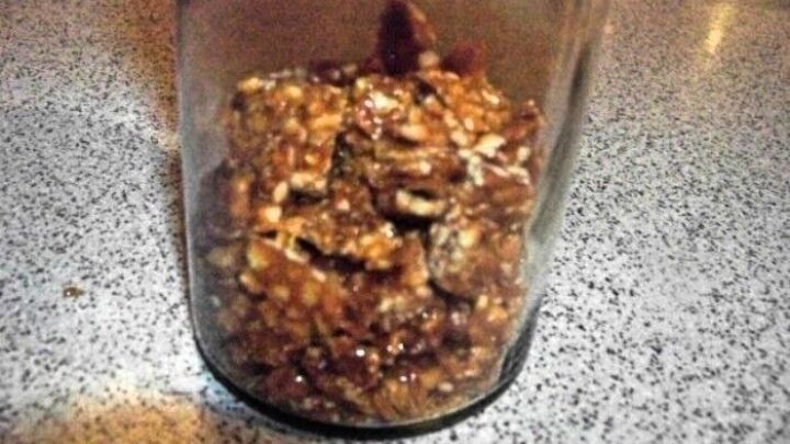 Ein Glas mit selbstgemachtem Knusper-Krokant steht auf einer grauen Arbeitsplatte und zeigt die knusprige, karamelisierte Mischung.