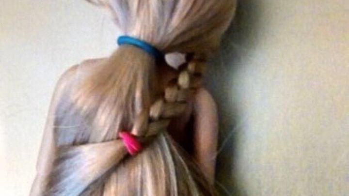 Eine Puppe mit langen Haaren hat Zopfgummis in verschiedenen Farben, die ihre Frisur halten und h&uuml;bsch aussehen.