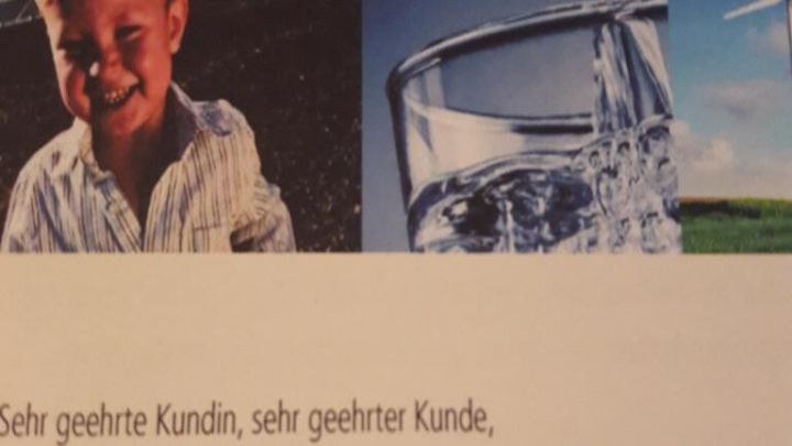 Ein Junge l&auml;chelt neben einem Wasserkrug, w&auml;hrend auf dem Dokument wichtige Informationen zur Verbrauchsabrechnung 2017 stehen.