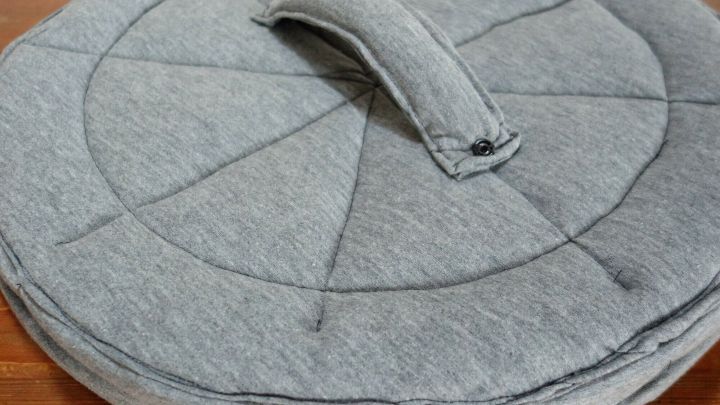 Ein runder, grauer Hut in Form einer M&uuml;lltonne liegt auf einem Holztisch, bereit f&uuml;r ein kreatives Faschingskost&uuml;m.