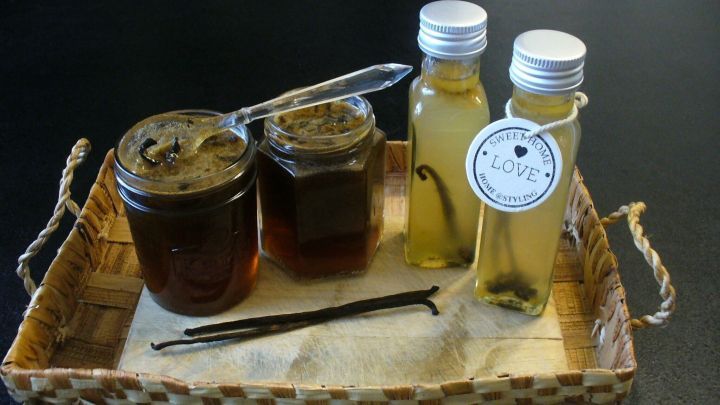 Zwei Fl&auml;schchen Vanilleextrakt und Gl&auml;ser mit Vanillepaste auf einem Tablett, umgeben von einer rustikalen Umgebung.