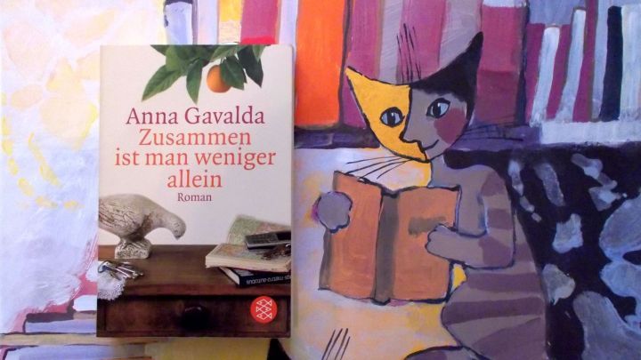 Das Buch "Zusammen ist man weniger allein" von Anna Gavalda liegt auf einem Tisch, umgeben von farbenfrohen Buchillustrationen.