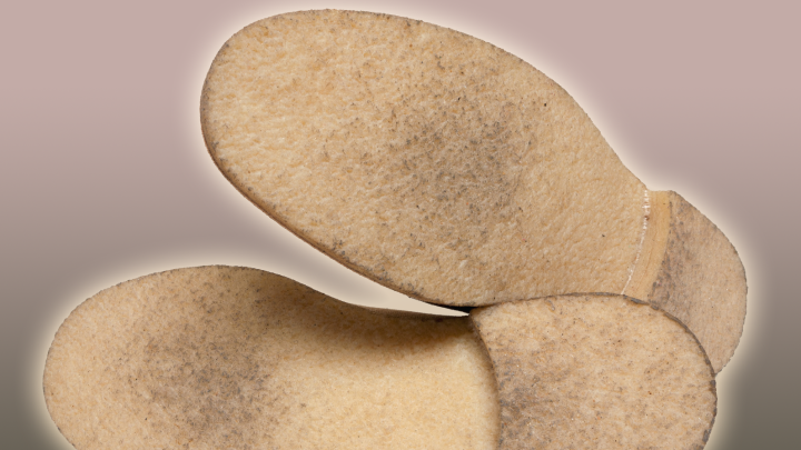 Abgenutzte, harte Kreppsohlen liegen nebeneinander auf einem sanften Hintergrund, bereit, wieder weich gemacht zu werden.