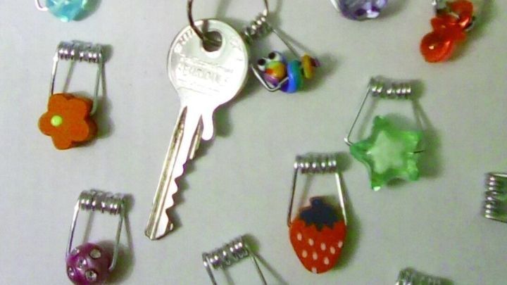 Niedliche Schl&uuml;sselanh&auml;nger liegen verstreut auf einem Tisch, w&auml;hrend ein Schl&uuml;ssel in der Mitte hervorsticht.