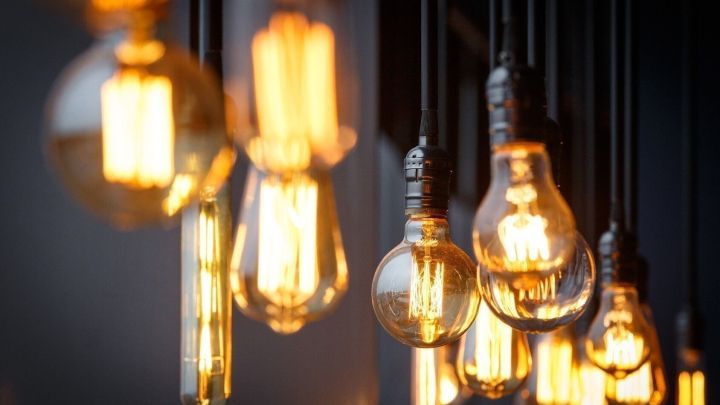 H&auml;ngende Gl&uuml;hbirnen strahlen warmes Licht aus und schaffen ein einladendes Ambiente in einem stilvollen Raum.