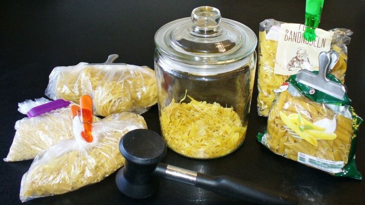 Trockene Nudelreste sind in verschiedenen Beh&auml;ltern auf einem Tisch aufbewahrt, um Restek&uuml;che effektiv zu gestalten.