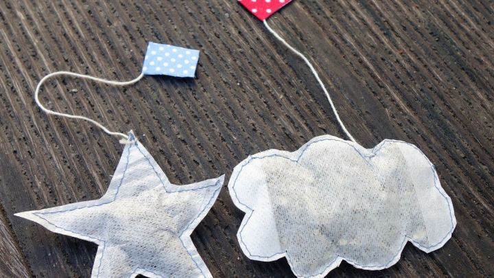Zwei originelle Teebeutel in Form eines Sterns und einer Wolke liegen auf einem Holztisch, bereit f&uuml;r eine DIY-Teemischung.