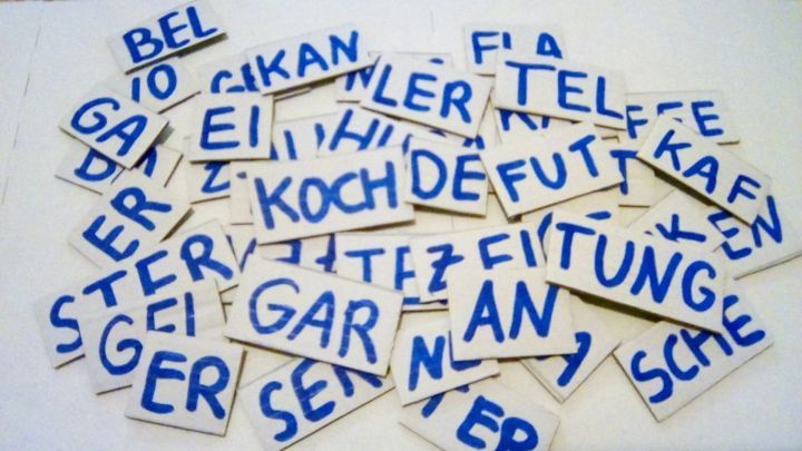 Karten mit Buchstaben liegen verstreut auf einem Tisch und laden Senioren zu einem Wortpuzzle ein.