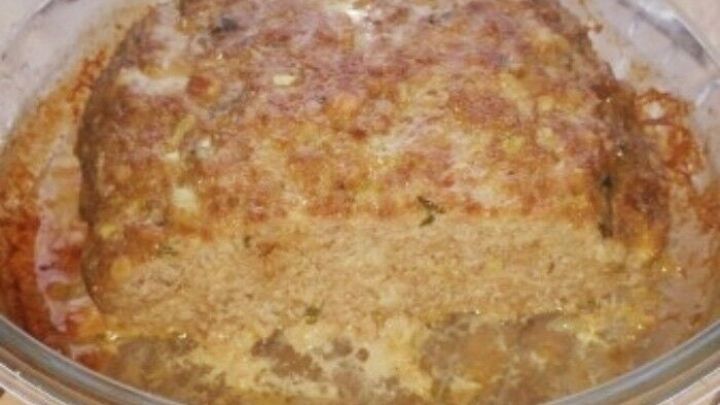 Ein goldbrauner Hackbraten steht in einer Mikrowellensch&uuml;ssel und dampft leicht, bereit zum Servieren.