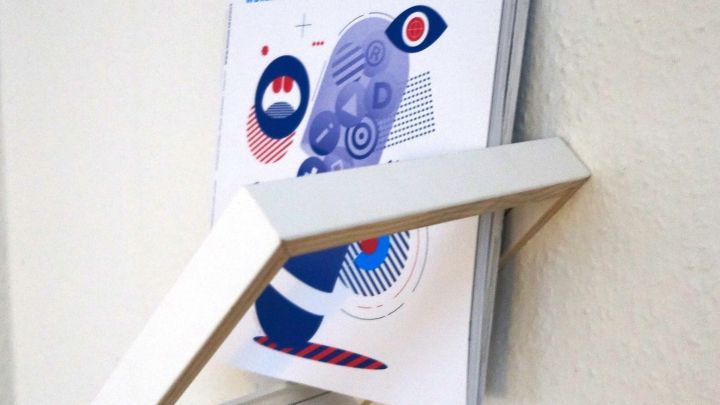 Ein stilvolles Zeitschriftenregal aus Bilderrahmen h&auml;lt die Zeitschrift "novum" an der Wand, modern und kreativ platziert.