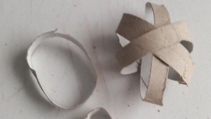 Ein bastelndes Katzen-Spielzeug, bestehend aus mehreren Papprollen, liegt auf einem Tisch und wartet auf einen spielenden Stubentiger.