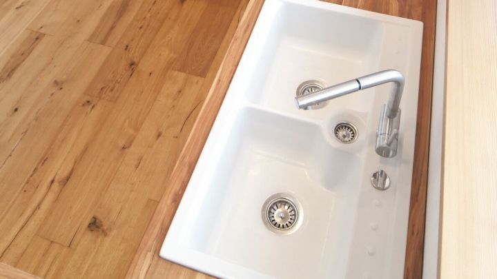 Eine moderne K&uuml;chensp&uuml;le wird mit Wasser gef&uuml;llt, um die Reinigung in einer hellen, einladenden K&uuml;che zu erm&ouml;glichen.