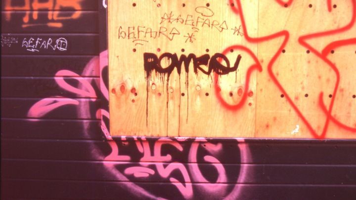 Eine Wand wird von Graffiti bedeckt, w&auml;hrend ein Holzschild mit dem Wort &bdquo;ROMARQ&ldquo; darauf montiert ist.
