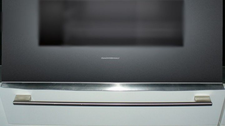 Der moderne Backofen zeigt Kondenswasser auf der Glasfront, w&auml;hrend er in einer modernen K&uuml;cheneinrichtung steht.