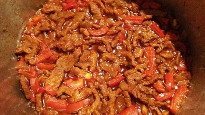 Zartes Rindergeschnetzeltes mit Paprika wird in einer Pfanne zubereitet und ist in einer schmackhaften Sauce angerichtet.