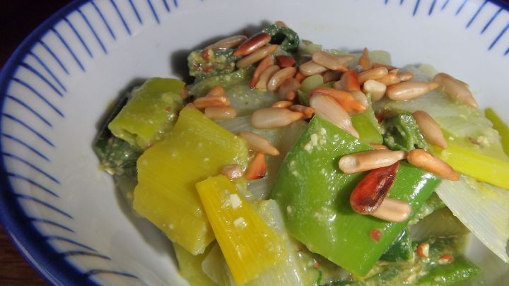 Ein bunter Lauchsalat mit Sonnenblumenkernen in einer flachen Sch&uuml;ssel, liebevoll angerichtet und frisch serviert.