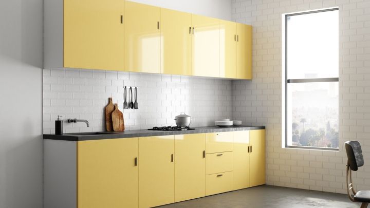 Helle K&uuml;chenschr&auml;nke mit gelben Fronten stehen in einer modernen K&uuml;che, bereit zur Reinigung von Fettbelag auf Fliesen.